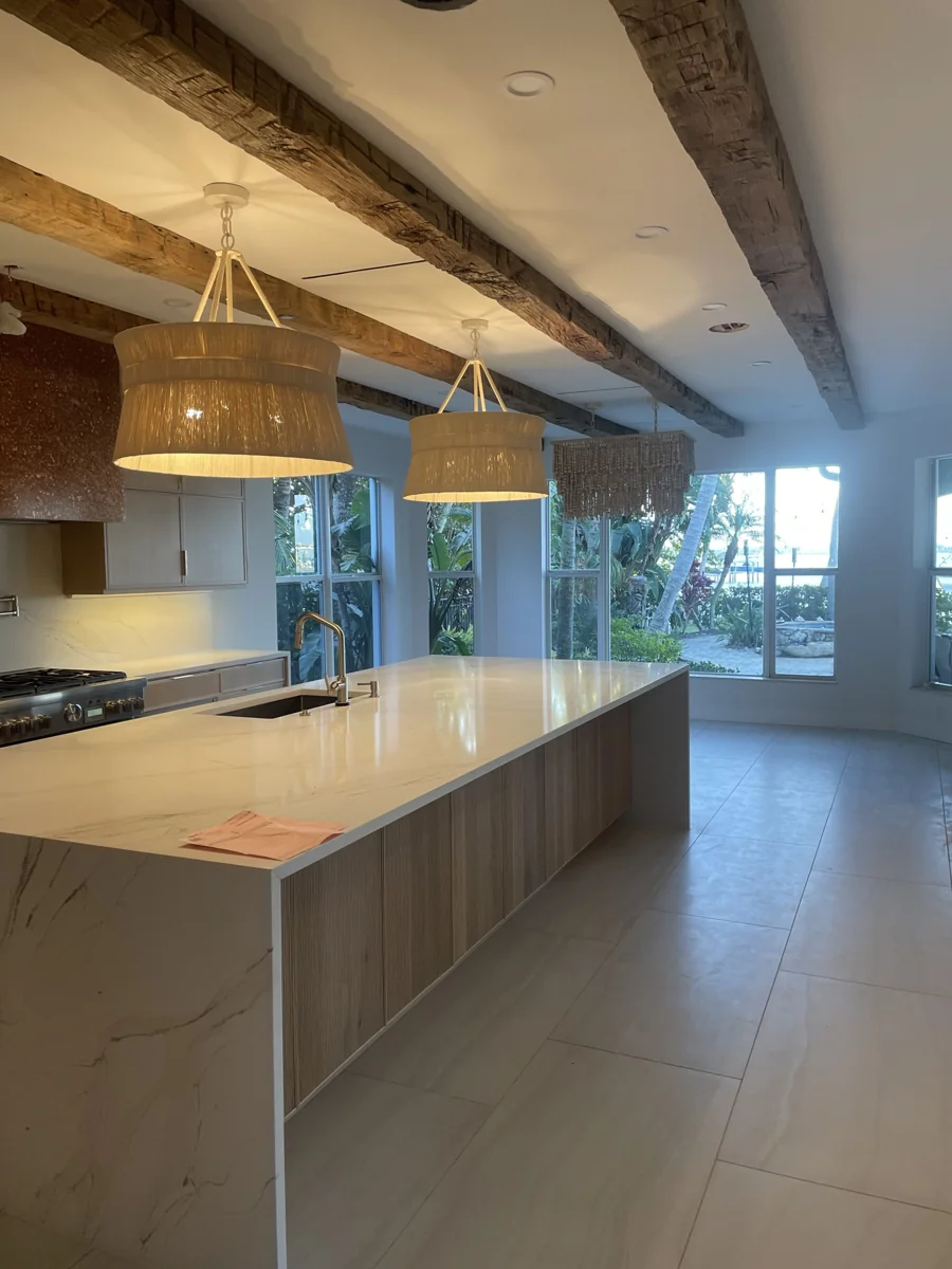 Kitchen renovation featuring exposed timber beams, stone island, and woven pendant lights